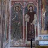 In basso si distinguono infine le figure di San Giovanni Battista che indossa pelli di animali e calzari di cuoio e di San Leonardo protettore dei carcerati, raffigurato con le catene
